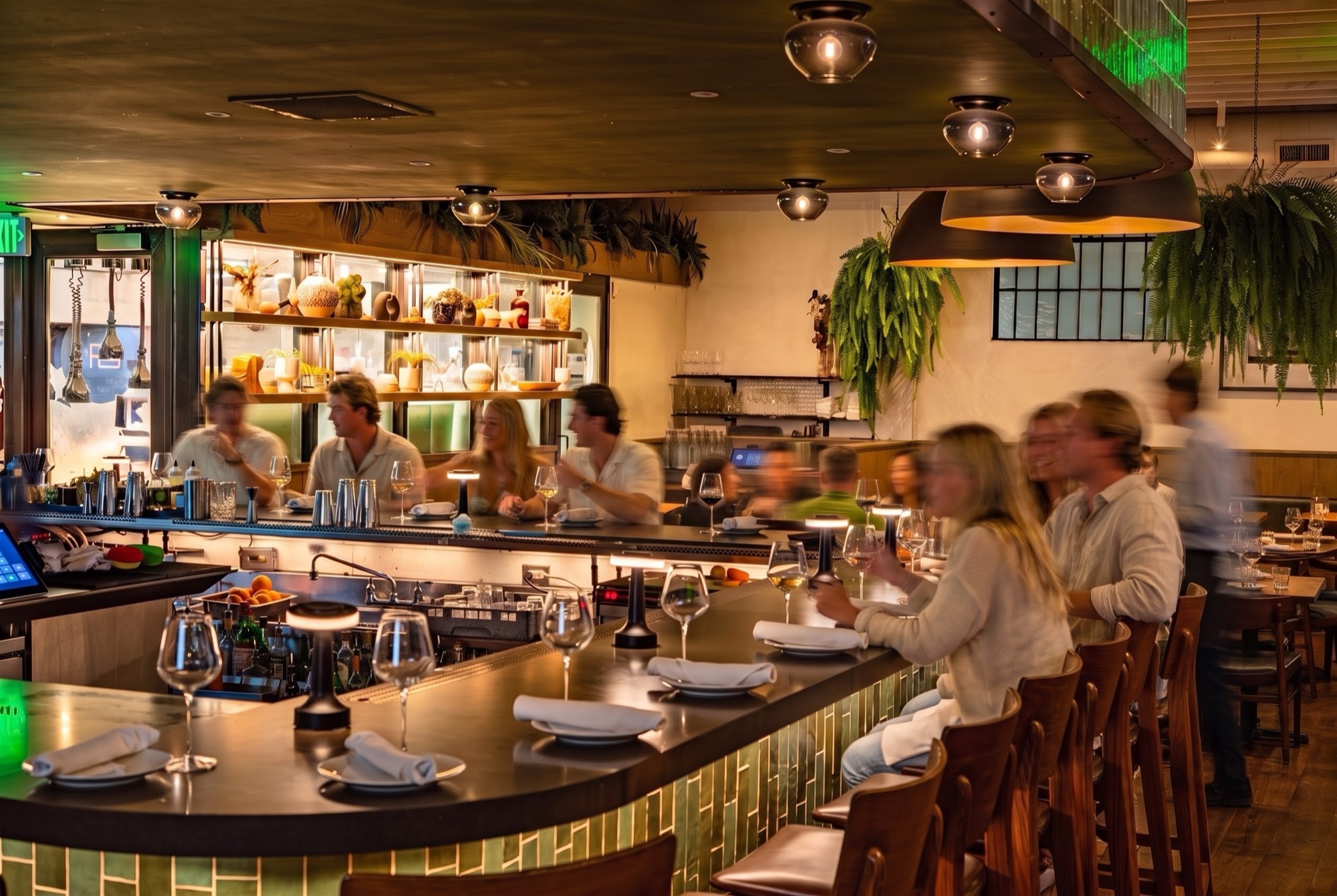 Guests at the green-tiled bar during a busy evening at M.B. Post